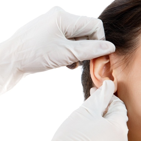 Cirurgião plástico verificando orelha feminina