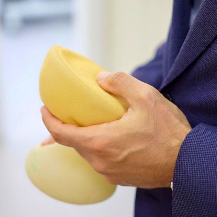 Dr. Moises De Melo explicando a escolha da prótese de silicone durante o planejamento cirúrgico da paciente.