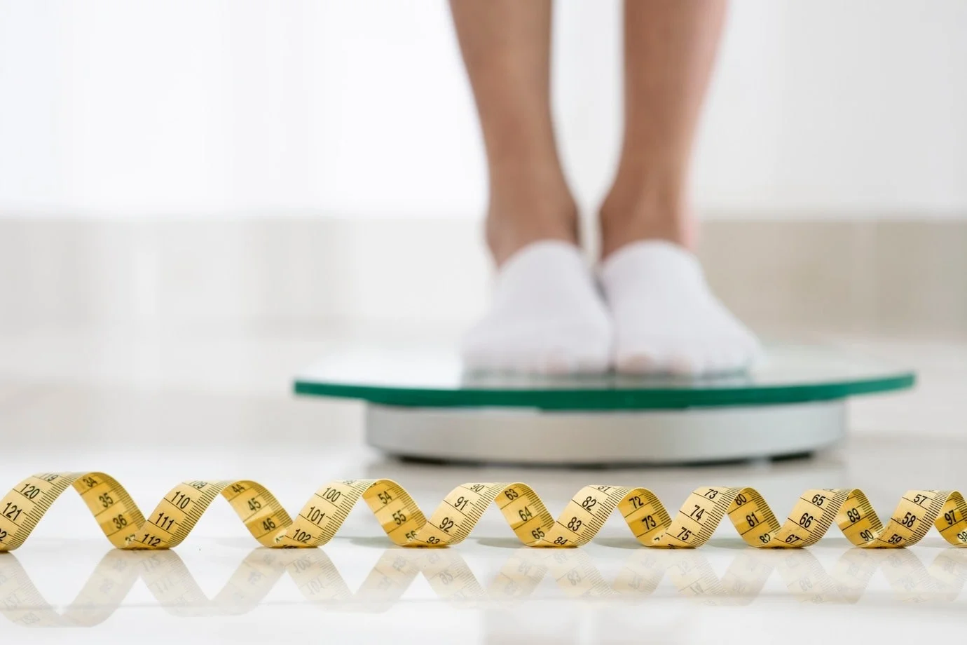 Mulher na balança para introduzir o tema: Qual é o peso ideal para realizar a cirurgia